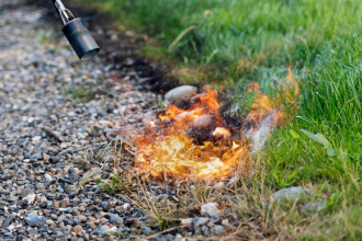 Désherbeur thermique gaz en action sur une allée pavée